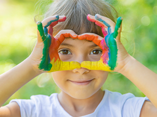 תמונת רקע למאמר ילדה עם צבעי גואש על הידיים, ממסגרת את העיניים
